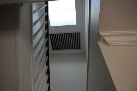 The Whole House Fan shutter is seen in a home’s stairwell centrally located to cool your whole home including the roof for less than a dollar a day!